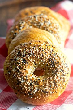 three bagels sitting on top of a red and white checkered table cloth next to each other