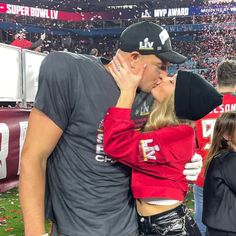 a man and woman kissing at a football game