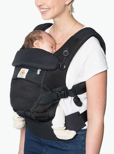 a woman holding a baby in a black carrier