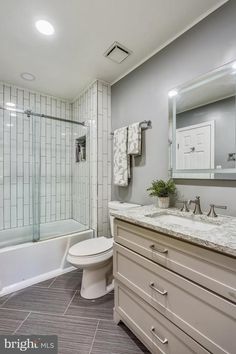 a bathroom with a sink, toilet and bathtub next to a walk in shower