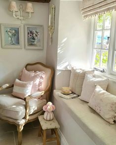 a white couch sitting next to a window in a living room with pillows on it