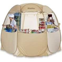 an outdoor kitchen tent with two people in it