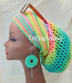 a mannequin head wearing a multicolored crochet hat and earrings