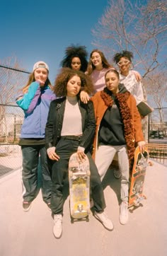 a group of young women standing next to each other with skateboards in their hands