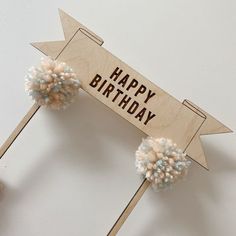 a wooden sign that says happy birthday with pom - poms