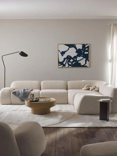 a living room filled with furniture and a painting on the wall