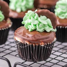 chocolate cupcakes with green frosting on a cooling rack