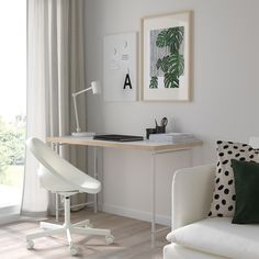 a white chair sitting in front of a desk with a computer on top of it