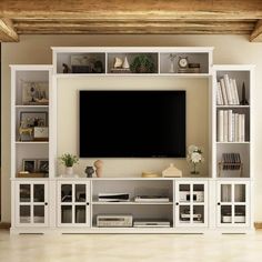 a living room with white furniture and a flat screen tv on top of a entertainment center