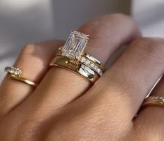 a woman's hand with two gold rings and one diamond ring on her finger