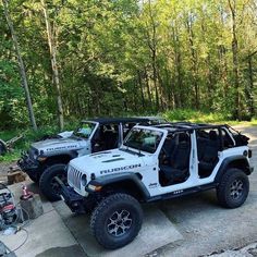 two white jeeps parked next to each other