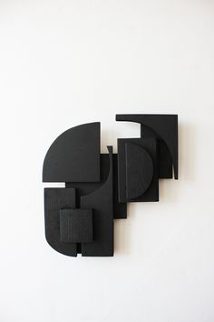 an abstract black sculpture on a white wall