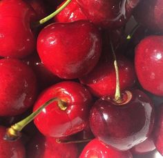 a pile of red cherries sitting on top of each other