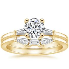 a yellow gold engagement ring with two baguets on the band and a round diamond center