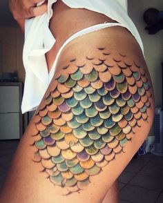 a woman's thigh with a fish tattoo on it