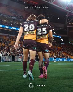 two rugby players are hugging each other on the field