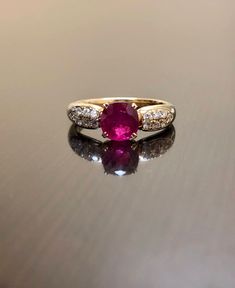 DeKara Designs Collection Metal- 18K Yellow Gold, .750. Stones- 1 Oval Ruby 1.05 Carats, 14 Round Diamonds G-H Color VS2 Clarity 0.25 Carats. Art Deco 18K Yellow Gold Ruby Diamond Engagement Ring. This ring features a beautiful reddish pink ruby that is professionally set in between four prongs. There are seven pave set diamonds on each side of the ruby. The yellow gold and the ruby compliment one another beautifully and the diamonds are the perfect finish to this amazing ring. Size- 7 1/2. FREE Classic Yellow Gold Gia Certified Ruby Ring, Classic Yellow Gold Ruby Ring Gia Certified, Luxury 14k Gold Ruby Wedding Ring, Luxury Yellow Gold Ruby Ring With Center Stone, Exquisite Ruby Ring With Center Stone, Fine Jewelry Gold Ruby Ring Gia Certified, Exquisite Yellow Gold Ruby Wedding Ring, Exquisite Yellow Gold Ruby Ring For Wedding, Heirloom Ruby Ring With Brilliant Cut