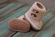 a pair of crocheted baby shoes sitting on top of a wooden floor next to each other