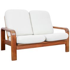 a wooden frame loveseat with two white cushions on the seat and backrests