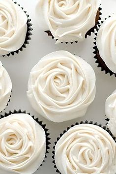 cupcakes with white frosting are arranged in rows