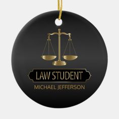 a black and gold law student ornament with an image of the scale of justice