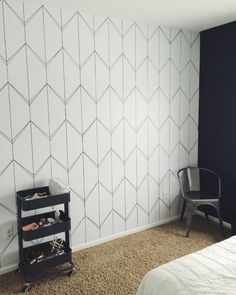 a bed room with a neatly made bed and a wallpapered pattern on the wall