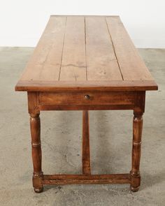 an old wooden table sitting on concrete floor