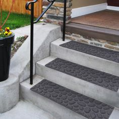 a set of steps leading up to a house with a potted plant next to it