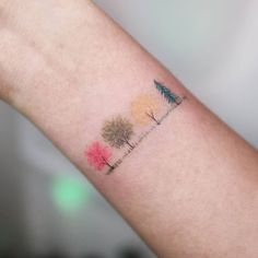 a small tree tattoo on the left arm and wrist is painted with watercolors