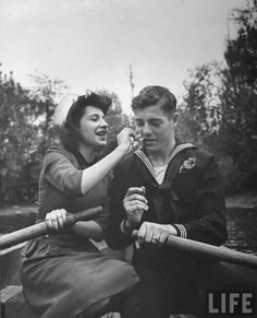 an old black and white photo of two people in a boat