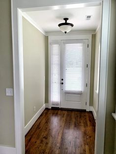 an empty room with wooden floors and white doors