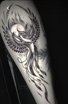 a black and white photo of a woman's arm with an owl tattoo on it