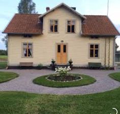 a yellow house with brown roof and windows