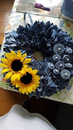 a sunflower sitting on top of a table next to a blue and yellow wreath