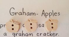 three wooden apples with leaves on them and the words graham - apples written in spanish