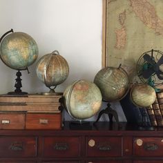 antique globes and books on top of an old dresser