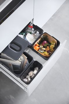 two containers with food in them sitting on top of a white table next to an open drawer