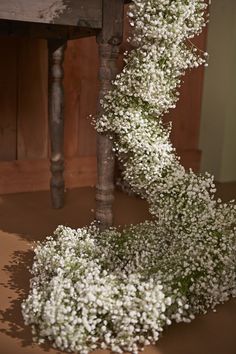 white baby's breath flowers on the ground next to a table