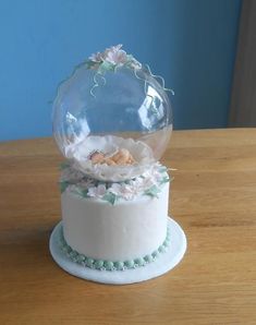 there is a snow globe on top of a cake that looks like it's floating in the air