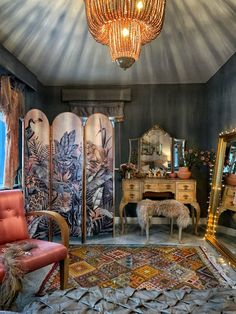 a room with an ornate chandelier hanging from the ceiling next to a chair and mirror