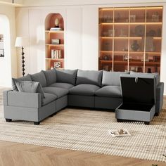 a living room with a sectional couch and bookcase on the wall next to it