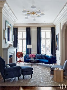 a living room with blue couches and chairs