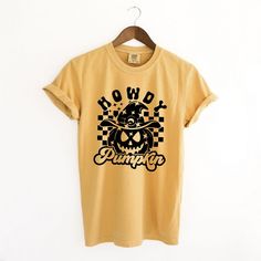 Looking for a cute versatile top to wear this summer? Make sure to grab one of our Howdy Pumpkin Checkered garment dyed graphic tees! This soft and comfortable graphic tee is the perfect top for any outfit. It can be paired with biker shorts, jeans, or even a simple skirt/dress! This tee is true-to-size, so be sure to order your regular t-shirt size! If you are looking for a more oversized look, make sure to size up! Acid Wash Pre-shrunk T-shirt For Fall, Pre-shrunk Acid Wash T-shirt For Fall, Acid Wash Graphic Tee Shirt, Fall Washed Cotton T-shirt, Fall Season Washed Cotton T-shirt, Yellow Cotton T-shirt For Fall, Yellow T-shirt With Screen Print For Fall, Fall Acid Wash Soft-washed T-shirt, Acid Wash Soft-washed T-shirt For Fall