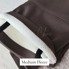 there is a brown and white blanket on top of a bed with the words medium fleece over it