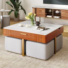 a coffee table with two stools underneath it and a vase filled with flowers on top