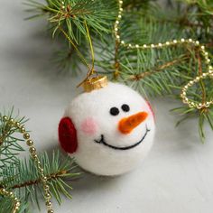 a snowman ornament hanging from a christmas tree