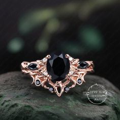 a black diamond ring sitting on top of a rock