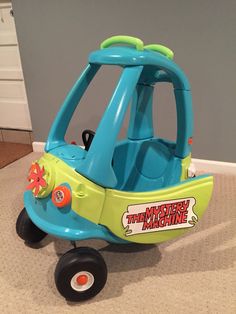 a blue and green toy car sitting on the floor