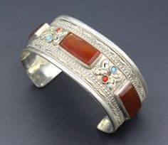 Vintage Turkmen traditional alpaka bracelet. Its 100% hand crafted workmanship with beautiful glass carnelian stones and lovely carved design. Please do not hesitate to contact if you have any questions. Weight : 41.1 grams, Opening of the mouth : 1.6" ( 4 cm ) Inner circumference : 15 cm ( 5.9" ) Width : 1" ( 2.6 cm ) Please know what you are bidding on. The metal of Most Kuchi, Afghan and Turkoman items are called with different names, Some called Alpaca silver, German Silver and Tibetan Silve Traditional Orange Bracelet Jewelry, Traditional Orange Bracelet, Handmade Silver Carnelian Beaded Bracelets, Traditional Adjustable Cuff Bracelet With Natural Stones, Traditional Cuff Bracelet With Natural Stones For Gift, Traditional Cuff Bracelet Bangle With Natural Stones, Traditional Silver Beaded Bracelets With Natural Stones, Orange Bohemian Bangle As A Gift, Bohemian Orange Bangle For Gifting