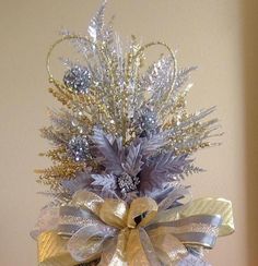 a silver and gold christmas tree with lots of decorations on it's top shelf